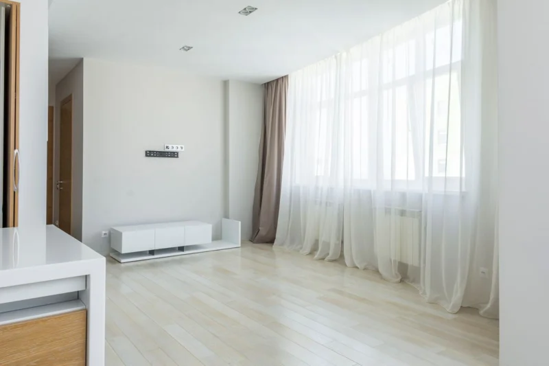 Bright rented flat with large windows and sheer curtains